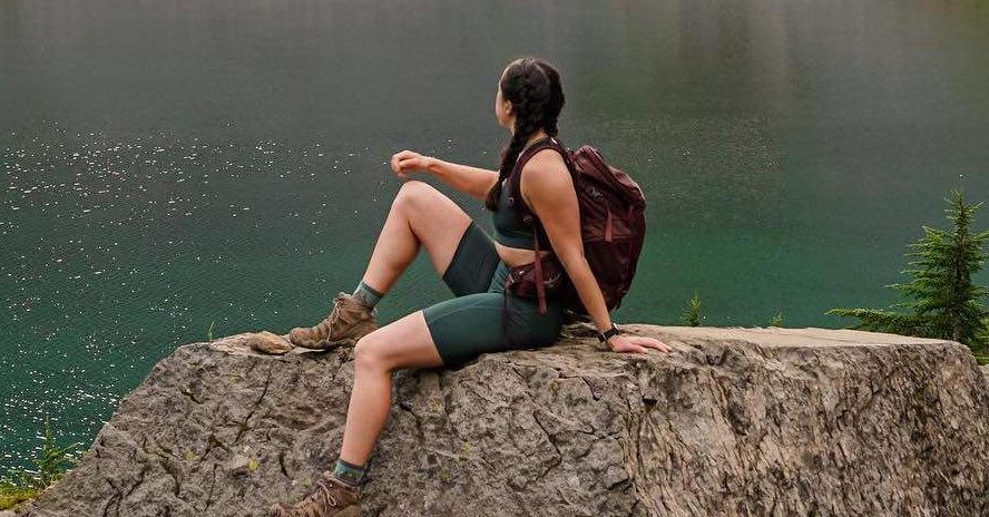 Woman Sits On A Stone While Hiking Trip